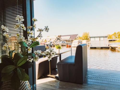 Uitgeest的住宿－Holiday Home De Meerparel-1 by Interhome，阳台配有桌子、椅子和植物