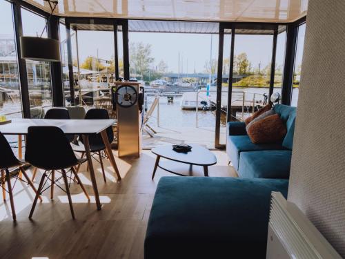 Una sala de estar con un sofá azul y una mesa. en Holiday Home Campi 400 by Interhome, en Uitgeest