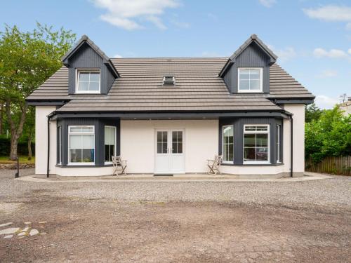 a white house with a black roof at Holiday Home Loch Ness House by Interhome in Drumnadrochit