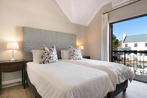 a bedroom with a large bed with a large window at Winelands Golf Lodges 11 in Stellenbosch