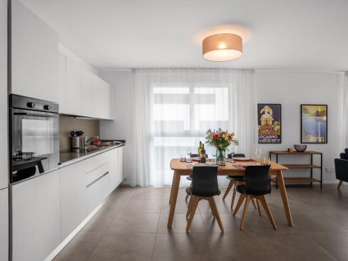 une cuisine avec une table et des chaises dans l'établissement Apartment LocTowers A3-7-3 by Interhome, à Locarno