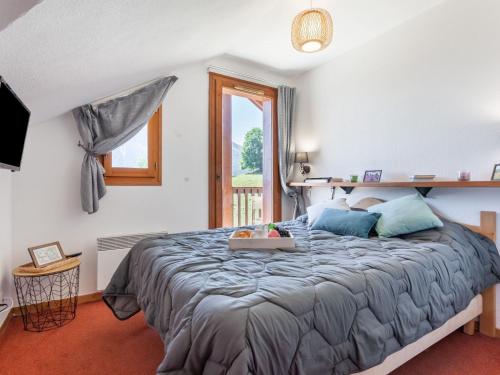 ein Schlafzimmer mit einem großen Bett und einem Fenster in der Unterkunft Apartment Les Alpages du Corbier-10 by Interhome in Le Corbier