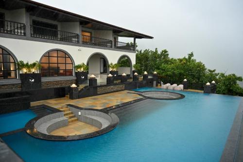 uma piscina em frente a uma casa em The Green Gate Resort Mulshi em Pune