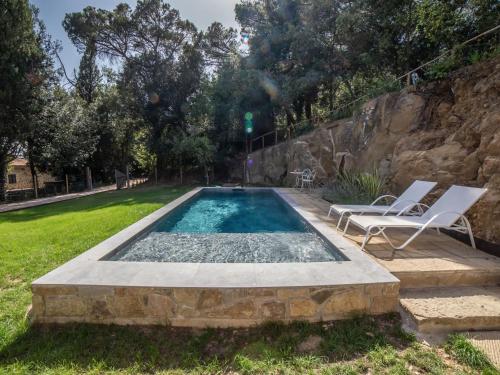 una piscina con 2 sillas y una pared de roca en Chalet Il Talamo by Interhome, en Castel Rigone