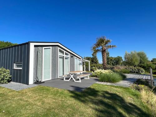 a small black building with a picnic table in a yard at Holiday Home Ruisweg 80 by Interhome in Wemeldinge