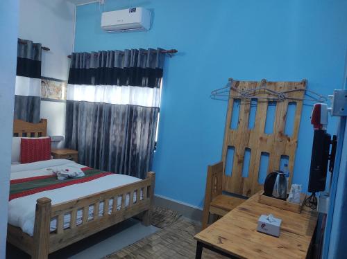 - une chambre avec un lit et un mur bleu dans l'établissement Hotel Mango Tree, à Birātnagar