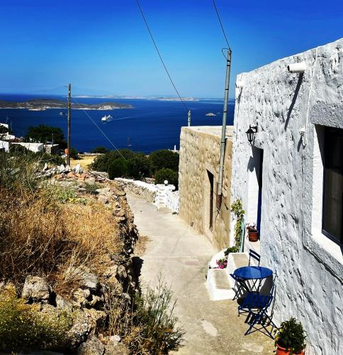 a stone house with a table and chairs on a hill at Patmos Horizon in Patmos