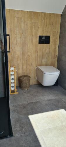 a bathroom with a white tub in a wooden wall at Pokoje na Szlaku Kajki 20A in Mikołajki