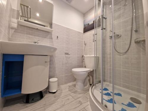 a bathroom with a sink and a toilet and a shower at Apartament Vincent in Ustronie Morskie