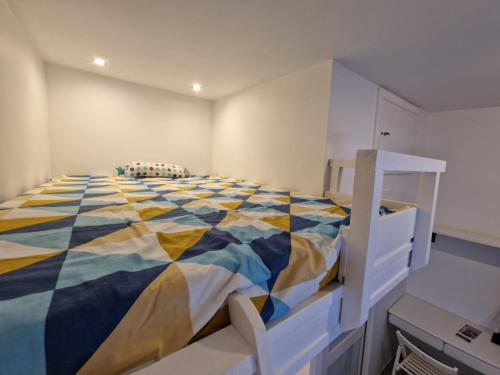 a bedroom with a large bed with a colorful comforter at Apartament Vincent in Ustronie Morskie