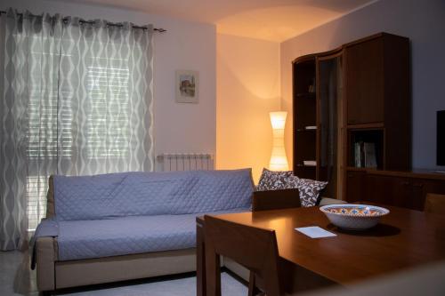 Casa degli Ulivi con parcheggio privato في Muro Lucano: غرفة معيشة مع أريكة زرقاء وطاولة