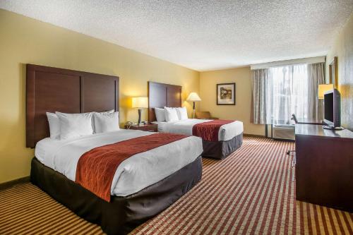 オーランドにあるComfort Inn & Suites Kissimmee by the Parksのベッド2台とテレビが備わるホテルルームです。