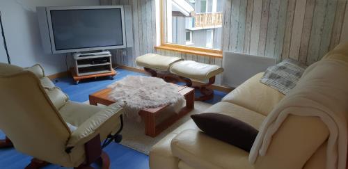 un salon avec deux chaises et une télévision dans l'établissement Gîte spacieux et lumineux proche centre ville, à Gérardmer