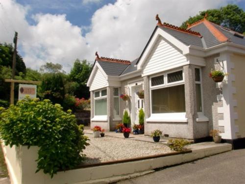 una casa blanca con plantas delante en Eden's Rest Bed and Breakfast en St Austell