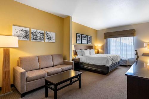 a hotel room with a bed and a couch at Sleep Inn & Suites in Miles City