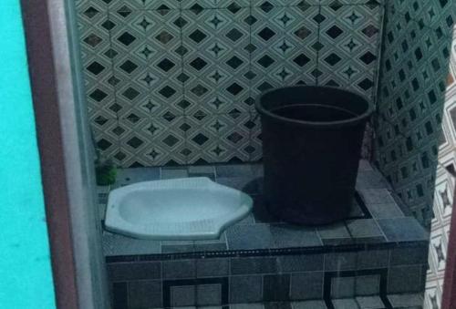 a bathroom with a toilet and a trash can at Penginapan asidik in Bira