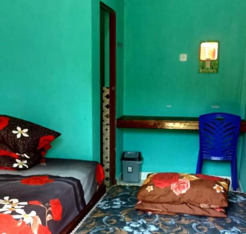 um quarto com uma cama e uma parede azul em Penginapan asidik em Bira