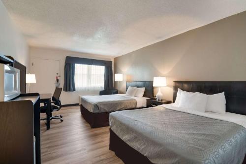 a hotel room with two beds and a flat screen tv at Econo Lodge Auburn I-95 in Auburn