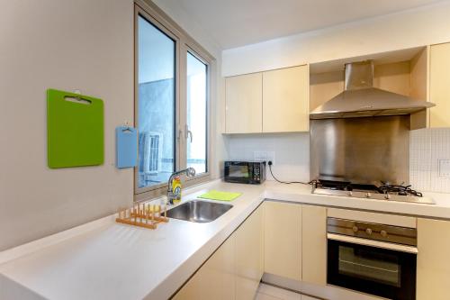 a white kitchen with a sink and a window at Rex Ollie @ Myhabitat Condominium in Kuala Lumpur