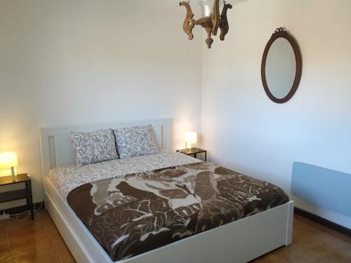 a bedroom with a bed and a mirror on the wall at Pé na Aldeia in Outeiro