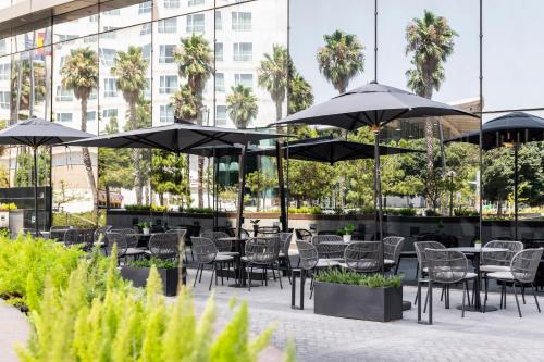 a patio with tables and chairs and umbrellas at Melia Valencia in Valencia