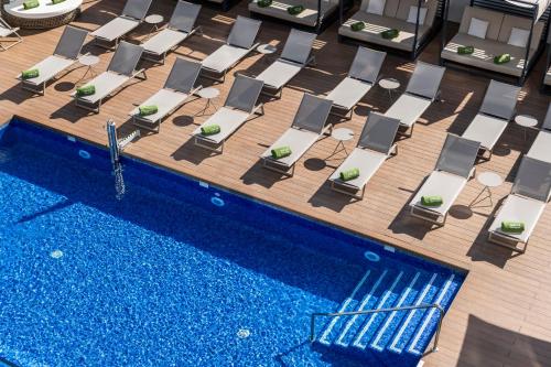an overhead view of a pool with lounge chairs and a swimming pool at Melia Valencia in Valencia