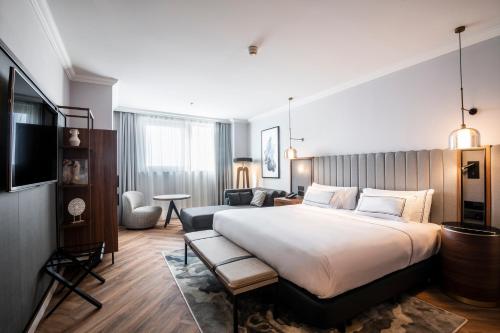 a bedroom with a large bed and a living room at Melia Valencia in Valencia