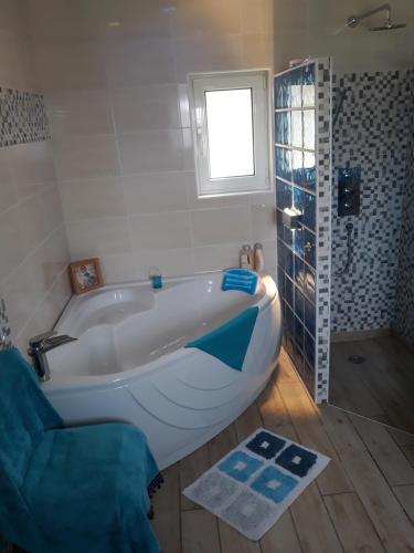 een badkamer met een wit bad en een raam bij Beautiful Cottage sea view near the beach Greece in Lixouri
