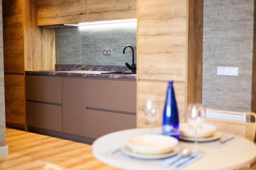 a kitchen with a table with plates and a sink at THE APARTMENT by assethoteles in Torrejón de Ardoz