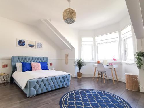 Schlafzimmer mit einem blauen Bett und einem Tisch in der Unterkunft Week2Week 4 BEDROOM BEACH HOME Free Netflix & Wifi in South Shields
