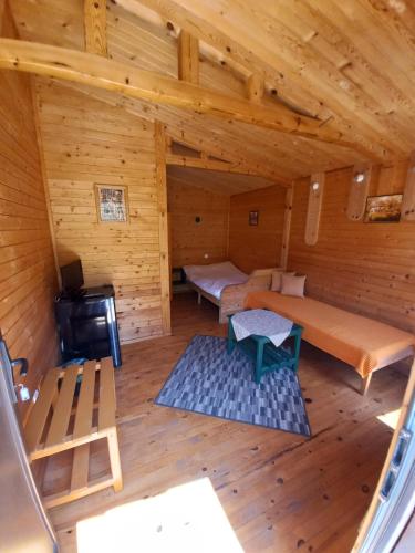 an overhead view of a log cabin with a bed and bench at Вилно селище МИРОВЕЦ in Malŭk Izvor