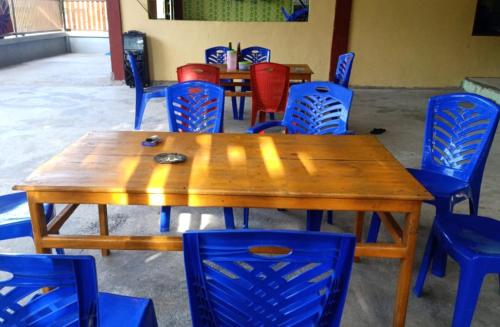 einen Holztisch und blaue Stühle in einem Zimmer in der Unterkunft Penginapan asidik in Bira
