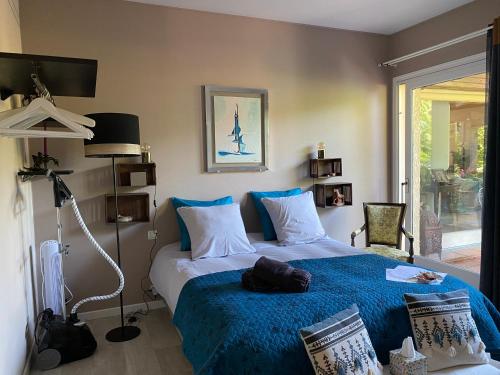 um quarto com uma cama com um cobertor azul em l'hacienda em Saint-Pierre-du-Mont