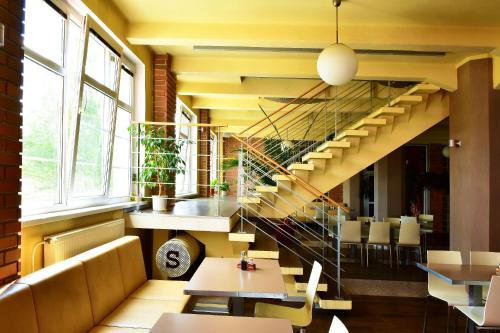 a restaurant with a staircase and tables and chairs at Hotel S-centrum Děčín in Děčín
