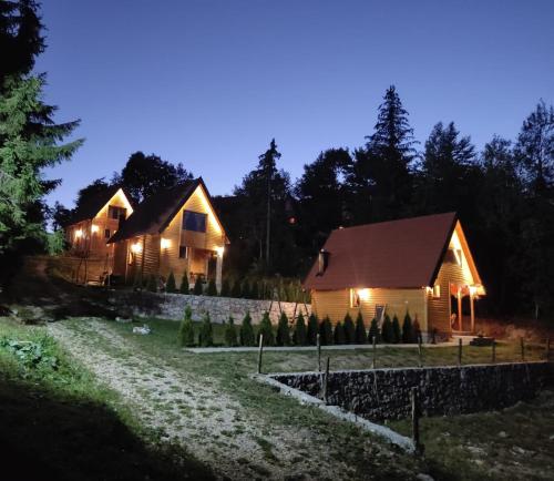 una casa por la noche con luces encendidas en Lodge Sisters en Sekulić 