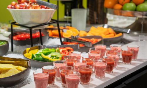 a table topped with glasses of drinks and bowls of fruit at Thon Hotel Polar in Tromsø