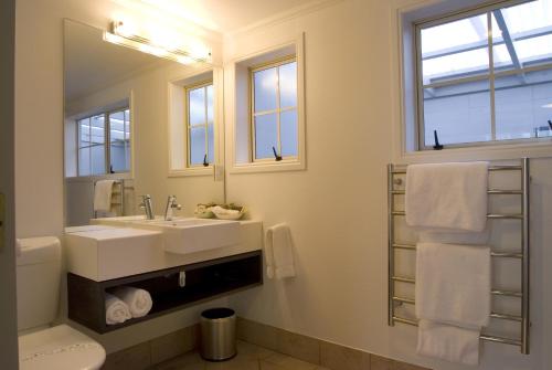 a bathroom with a sink and a mirror at Silver Fern Rotorua Suites & Spa in Rotorua