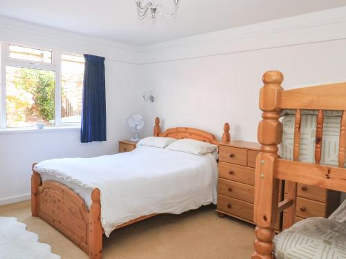 a bedroom with a wooden bed and a dresser at Flat 18 in Paignton