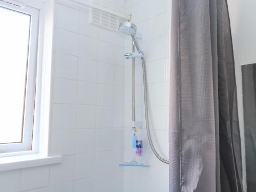 a shower with a shower head in a bathroom at Flat 18 in Paignton