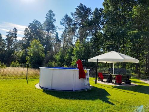 a hot tub in a yard with an umbrella at Dom Wczasowy Smyk in Biskupiec
