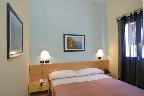 1 dormitorio con 1 cama con 2 almohadas y ventana en Villetta Lilly - Belvedere Pugnochiuso - Gargano en Vieste