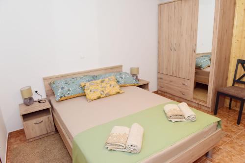 a bedroom with a bed with two towels on it at Apartman Bingo in Josipdol