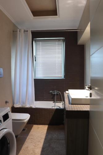 een badkamer met een bad, een toilet en een wastafel bij Virna s home in Schinias
