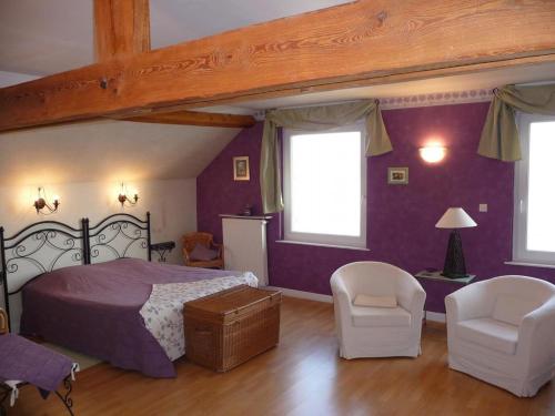 een slaapkamer met paarse muren en een bed en stoelen bij gite du chêne in Bierne