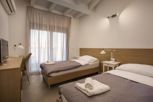 ein Hotelzimmer mit 2 Betten und einem Fenster in der Unterkunft Villa Monte D'Or in Krnica
