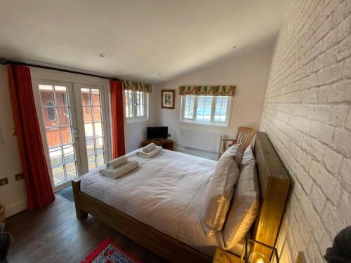 a bedroom with a large bed in a room with windows at Nightjar in Ockley