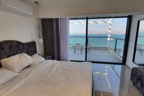a bedroom with a bed and a view of the ocean at H-MOMIS טבריה. אחד העם 3 in Tiberias