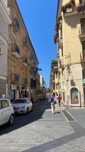 a person walking down a city street with buildings at Porta Saracena Rooms in Agropoli