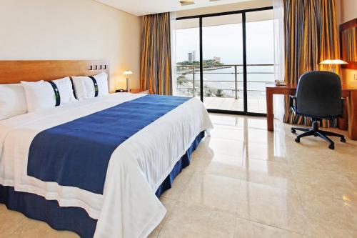 a hotel room with a bed and a desk and a window at Holiday Inn Veracruz-Boca Del Rio, an IHG Hotel in Veracruz