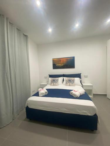 a bedroom with a large bed with blue and white sheets at Porta Saracena Rooms in Agropoli